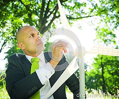 Businessman holding wind turbine in the woods Stock Photo