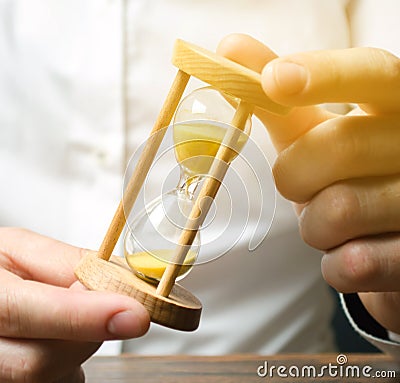 Businessman holds clock in hands. Concept of saving time and money. Time management. Planning work. Reduced cost and bureaucratic Stock Photo