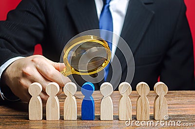 Businessman holds a magnifying glass over a worker. Recruitment concept. Hiring, hire. The best employee, leader. Leadership and Stock Photo