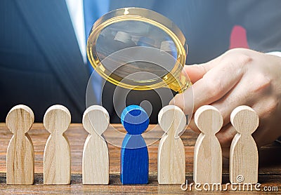 Businessman holds a magnifying glass over a worker. Recruitment concept. Hiring, hire. The best employee, leader. Leadership and Stock Photo