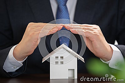 Businessman with house model on the desk. Real estate concept Stock Photo