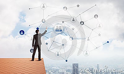 Businessman on house roof presenting networking and connection concept. Mixed media Stock Photo