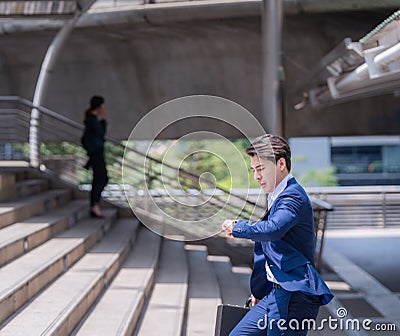 Businessman in a hurry checking time and running, he is late for work his business appointment. Stock Photo