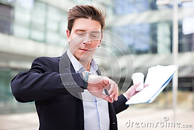 Businessman hurrying to meeting and watching on wristwatch Stock Photo