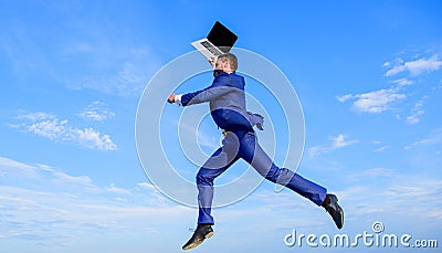 Businessman inspired entrepreneur feels powerful going to change world. Man inspired holds laptop above while jump Stock Photo