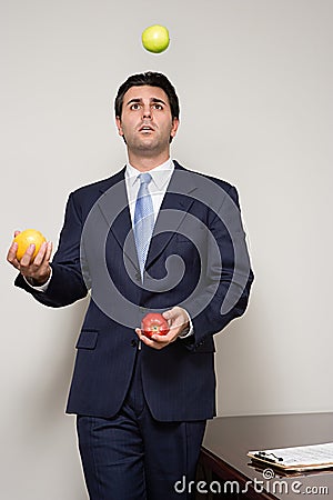 Businessman juggling fruit Stock Photo