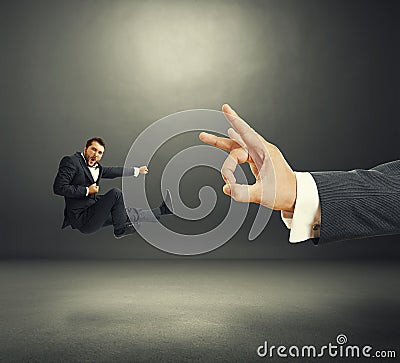 Businessman kicking, big hand flicking Stock Photo