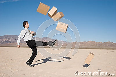 Businessman kicking boxes Stock Photo