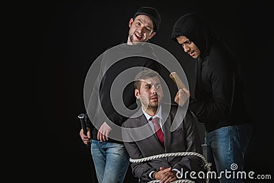 Businessman kidnapped by two robbers in black zoodies Stock Photo