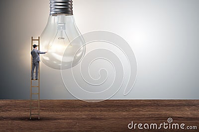 The businessman on ladder with light bulb Stock Photo