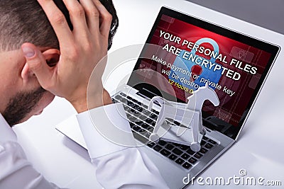 Businessman With Laptop Screen Showing Ransomware Message Stock Photo