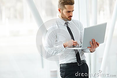 Businessman with laptop. Young Businessman Typing Something on L Stock Photo