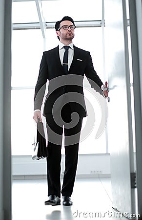 Businessman with a leather briefcase entering his client`s office. Stock Photo