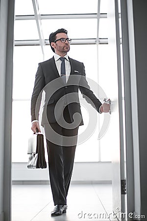 Businessman with a leather briefcase entering his client`s office. Stock Photo