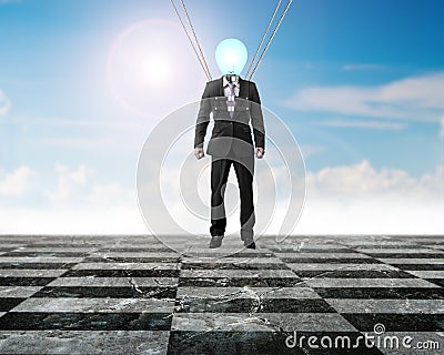 Businessman of light bulb head landing on chessboard ground Stock Photo