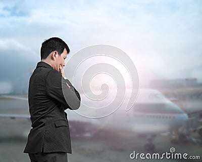 A businessman looking airplane at an airport Stock Photo