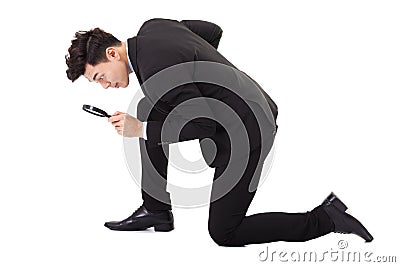 Businessman looking through magnifying glass Stock Photo