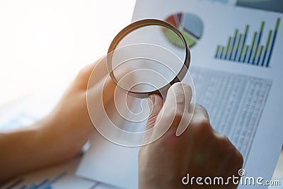 Businessman looking through a magnifying glass to documents. Business assessment and audit. Magnifying glass on a financial report Stock Photo