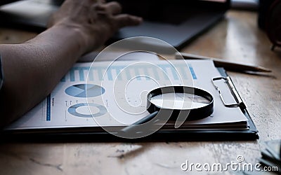 Businessman looking through a magnifying glass to documents. Business assessment and audit. Magnifying glass on a financial report Stock Photo