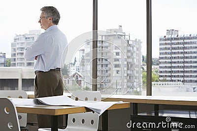 Businessman Looking Through Office Window Stock Photo