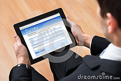 Businessman Looking At Online Survey Form Stock Photo