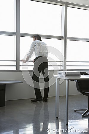 Businessman Looking Out Of Office Window Stock Photo