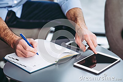 Businessman making notes in notebook Stock Photo