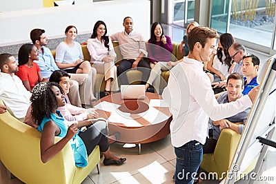 Businessman Making Presentation To Office Colleagues Stock Photo