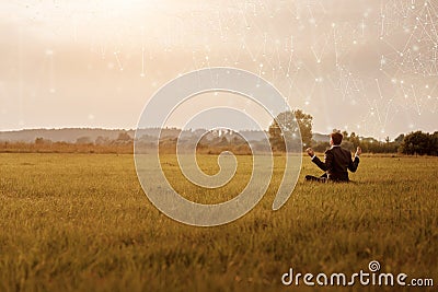 Businessman meditates in a field on the Internet Stock Photo