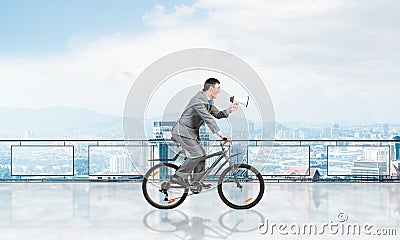 Businessman with megaphone in hand on bike Stock Photo