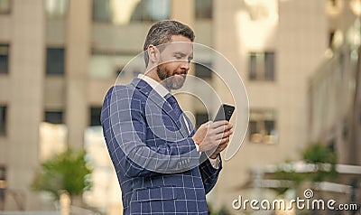 businessman messaging on phone in the street. businessman messaging on phone Stock Photo