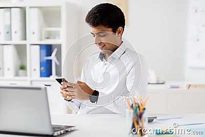 Businessman messaging on smartphone at office Stock Photo