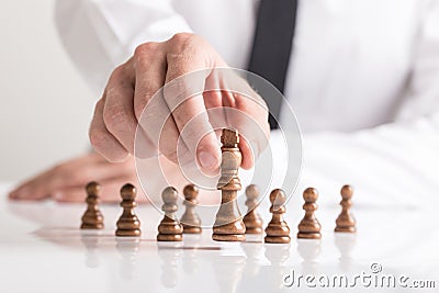 Businessman moving dark King chess piece at white table Stock Photo