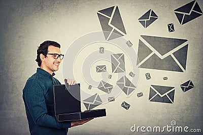 Businessman opens briefcase filled with different messages as lots of envelope symbols comes out of the box. Ingenious boss shares Stock Photo