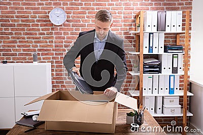 Businessman Packing His Belongings In Cardboard Box Stock Photo