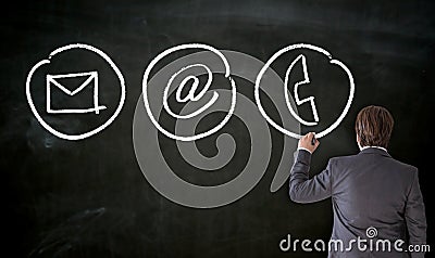 Businessman paints with chalk contact options on blackboard Stock Photo