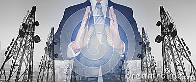 Businessman with panoramic double exposure telecommunication towers, and city in sunset background Stock Photo