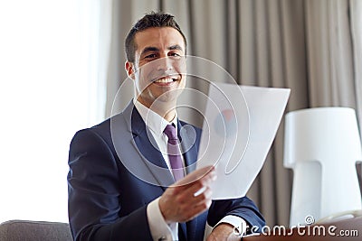 Businessman with papers working at hotel room Stock Photo