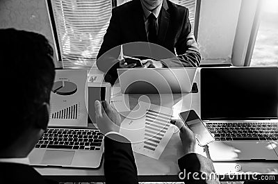 Businessman people playing with smartphones while meeting and ignoring each other. Boring meeting concept in black and white color Stock Photo