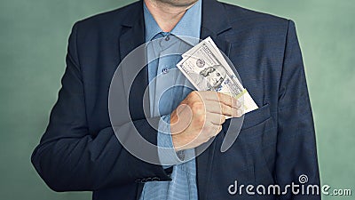 corrupt politician. businessman placing dollar money into his pocket as after a successful deal or bribe. corrupt Stock Photo