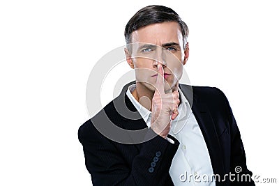 Businessman placing finger on lips saying shhh Stock Photo