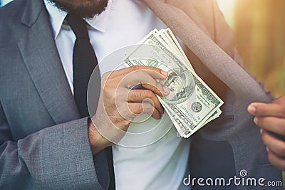 Businessman placing money into his pocket. Stock Photo