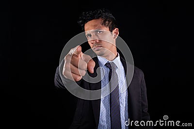 Businessman pointing forward with his finger. Young adult with serious and distrustful expression judging with finger Stock Photo