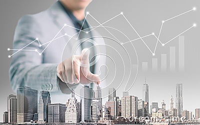 Businessman pointing his finger and touch the screen with building foreground and financial info-graphic Stock Photo