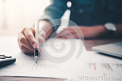 Businessman pointing with pen on business report chart are working on accounts in business analysis with graphs and documentation Stock Photo