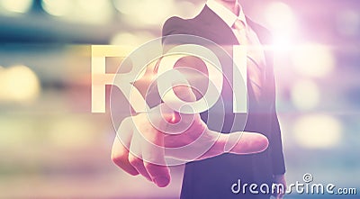 Businessman pointing at ROI (return on investment) Stock Photo