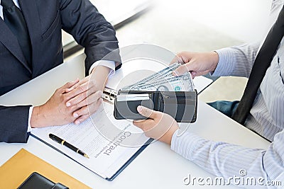 Businessman or politician taking bribe and Shaking Hands With Money in a suit, corruption trade exchange concept Stock Photo