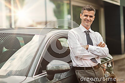 Businessman posing with his car Stock Photo