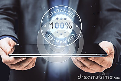 Businessman presenting a digital guarantee badge hologram on a tablet Stock Photo