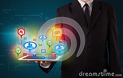 Businessman presenting modern tablet with colorful social signs Stock Photo